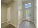 Bright entryway with wood-look tile flooring and transom window above the front door at 2164 Crosston Cir, Orlando, FL 32824