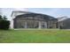 Backyard view of a screened-in pool offers a private oasis for relaxation and recreation at 257 Lancaster Dr, Davenport, FL 33897
