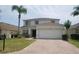 Charming two-story home with a brick driveway, well-manicured lawn and a palm tree at 257 Lancaster Dr, Davenport, FL 33897