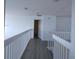 Upstairs hallway showcases new vinyl flooring and white railing, providing a secure barrier at 257 Lancaster Dr, Davenport, FL 33897