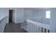 Second-floor hallway with gray vinyl flooring, white banisters, and plenty of natural light at 257 Lancaster Dr, Davenport, FL 33897