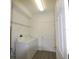 Functional laundry room with white appliances, utility shelving, and easy access to other rooms at 257 Lancaster Dr, Davenport, FL 33897