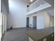 Bright, open living room features high ceilings, lots of natural light, and a staircase to the second floor at 257 Lancaster Dr, Davenport, FL 33897