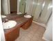 Bathroom vanity with double sinks, mirror, and glass-enclosed shower stall at 3001 Greystone Loop # 106, Kissimmee, FL 34741