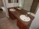 Bathroom vanity with double sinks, a large mirror and tile flooring at 3001 Greystone Loop # 106, Kissimmee, FL 34741