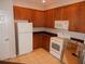 Kitchen features wood cabinets, white appliances, and tile flooring at 3001 Greystone Loop # 106, Kissimmee, FL 34741
