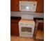 White kitchen range with cooktop and oven below a matching microwave and wood cabinetry at 3001 Greystone Loop # 106, Kissimmee, FL 34741