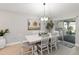 Bright dining room with a white table, stylish lighting, and a view of the outdoor patio at 3211 Sweet Acres Pl, St Cloud, FL 34772