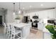 Bright kitchen featuring a large island, pendant lights, white cabinets, and stainless steel appliances at 3211 Sweet Acres Pl, St Cloud, FL 34772