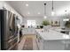 Bright kitchen with stainless steel appliances, white cabinets, large island, and stylish pendant lighting at 3211 Sweet Acres Pl, St Cloud, FL 34772