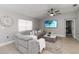 Comfortable living room featuring a large sectional sofa, ceiling fan, and beach view on TV at 3211 Sweet Acres Pl, St Cloud, FL 34772