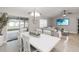 Open-concept living room features a dining area, sofa, television, and view to the backyard at 3211 Sweet Acres Pl, St Cloud, FL 34772