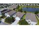 An aerial view of a neighborhood showcases the house, its well-maintained lawn, and a nearby pond, all under a bright, sunny sky at 3333 Sagebrush St, Harmony, FL 34773