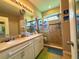 Bright bathroom with dual sinks, framed mirror, a shower with fish decorations, and tile flooring at 3333 Sagebrush St, Harmony, FL 34773