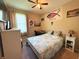 Cozy bedroom featuring a full bed, ceiling fan, side table, desk, and personal touches providing a homely feel at 3333 Sagebrush St, Harmony, FL 34773