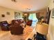 A cozy living room with leather furniture, a unique patterned rug, and natural light filtering through the sliding glass doors at 3333 Sagebrush St, Harmony, FL 34773