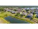 Picturesque aerial view of homes with pools and serene ponds in a vibrant, green neighborhood at 3391 Cortland Dr, Davenport, FL 33837