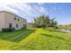 Spacious backyard bordering a serene pond, with lush lawn and mature trees, creating a peaceful retreat at 3391 Cortland Dr, Davenport, FL 33837