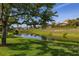 Scenic backyard view with lush greenery, a tranquil pond, and neighboring houses at 3391 Cortland Dr, Davenport, FL 33837