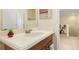 Bathroom vanity with a cream countertop, wood cabinets, and a mirror with bright lighting at 3391 Cortland Dr, Davenport, FL 33837