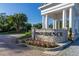 The entrance to Providence community with a stone sign, flowers, and a covered portico at 3391 Cortland Dr, Davenport, FL 33837