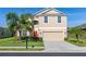 Two-story home with a two car garage, landscaped yard and a vibrant red front door at 3391 Cortland Dr, Davenport, FL 33837