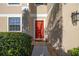 Inviting home exterior featuring a vibrant red front door and lush landscaping at 3391 Cortland Dr, Davenport, FL 33837