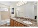 Well-lit bathroom featuring a double vanity, granite countertop, and a shower-tub combination at 341 Lasso Dr, Kissimmee, FL 34747