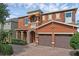 Charming two-story home features a brick driveway, a two-car garage, and manicured landscaping at 341 Lasso Dr, Kissimmee, FL 34747