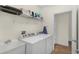 Functional laundry room featuring a washing machine, dryer, sink, and storage shelf at 341 Lasso Dr, Kissimmee, FL 34747