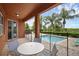 Relaxing covered patio with comfortable seating overlooking the sparkling pool and palm trees at 341 Lasso Dr, Kissimmee, FL 34747