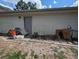 Backyard view showing the side of the house with a door and a cluttered yard at 4345 Old Colony Rd, Mulberry, FL 33860