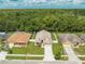 Aerial view of a home with a manicured lawn, two-car garage, and proximity to lush greenery at 4726 Ashurst St, Kissimmee, FL 34758