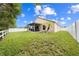Well-maintained backyard with lush green lawn, privacy fence, covered patio and young palm trees for tropical appeal at 4726 Ashurst St, Kissimmee, FL 34758