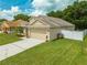 Tan single Gathering home with an attached two car garage and an enclosed backyard at 4726 Ashurst St, Kissimmee, FL 34758