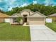 Charming single-story home featuring a well-manicured lawn, mature landscaping, and an attached two-car garage at 4726 Ashurst St, Kissimmee, FL 34758