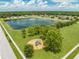 Aerial view of a neighborhood playground with blue and green equipment near a scenic pond at 4726 Ashurst St, Kissimmee, FL 34758