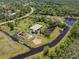 Expansive aerial view of a serene property with a charming home, pond, and lush greenery at 4730 Cypress Creek Ranch Rd, St Cloud, FL 34771
