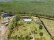 Idyllic aerial view of a homestead featuring a metal roof home, ponds, and verdant surroundings at 4730 Cypress Creek Ranch Rd, St Cloud, FL 34771