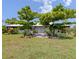 Charming single-story home featuring a light-blue facade, covered porch, lush landscaping, and mature trees in the front yard at 4730 Cypress Creek Ranch Rd, St Cloud, FL 34771