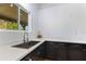 Modern kitchen features white countertops, stainless steel sink, and black cabinetry offering a blend of style and functionality at 4730 Cypress Creek Ranch Rd, St Cloud, FL 34771