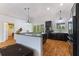 Modern kitchen featuring a breakfast bar, dark cabinetry, stainless steel appliances, and hardwood floors at 4730 Cypress Creek Ranch Rd, St Cloud, FL 34771