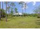 Large, open yard showcasing the home and complemented by mature trees that enhance privacy and appeal at 4730 Cypress Creek Ranch Rd, St Cloud, FL 34771