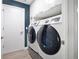 A modern laundry room with new front loading washer and dryer and clean white cabinets at 501 Dunoon St, Ocoee, FL 34761