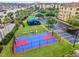 Aerial view of the community basketball court and playground situated amidst a well-maintained landscape at 5038 Tideview Cir # 21, Orlando, FL 32819