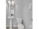 Powder room with pedestal sink, modern toilet, mirror, and natural wood look flooring at 5038 Tideview Cir # 21, Orlando, FL 32819