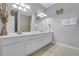 Bathroom featuring a dual sink vanity with large mirrors, modern lighting, and wood look flooring at 5038 Tideview Cir # 21, Orlando, FL 32819
