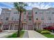 Three-story townhome featuring individual garages, private entrances and lush tropical landscaping with palm tree at 5038 Tideview Cir # 21, Orlando, FL 32819