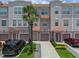 Three-story townhome featuring individual garages, private entrances and lush tropical landscaping with palm trees at 5038 Tideview Cir # 21, Orlando, FL 32819