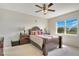 Comfortable bedroom featuring a ceiling fan, large window and a view of the backyard at 5133 Chickadee St, St Cloud, FL 34771
